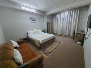 - un salon avec un lit et un canapé dans l'établissement Payong House, à Gangtok