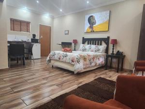 a living room with a bed and a kitchen at South Gate Country Lodge in Polokwane
