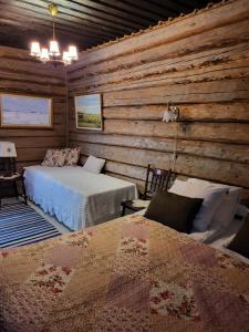 1 dormitorio con 2 camas en una cabaña de madera en Villa Miilia maalaismajoitus ja spa, en Karijoki