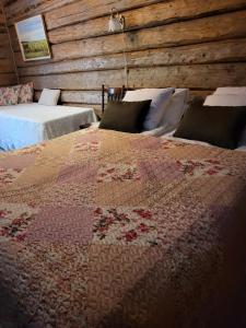 een slaapkamer met 2 bedden en een quilt op een bed bij Villa Miilia maalaismajoitus ja spa in Karijoki