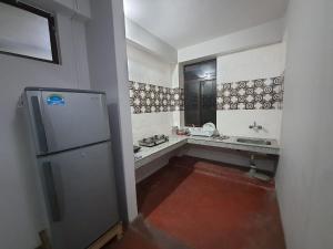 eine kleine Küche mit Spüle und Kühlschrank in der Unterkunft Payong House in Gangtok