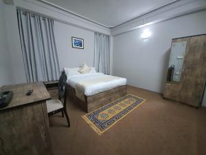 1 dormitorio con cama, mesa y escritorio en Payong House, en Gangtok