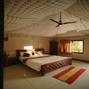 a bedroom with a bed and a ceiling with a fan at Bharat Lake view Resort- Pure Veg Restaurant in Udaipur