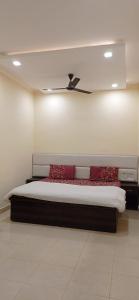1 dormitorio con cama con almohadas rojas y techo en Hotel Amar Inn, en Jalandhar