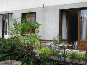 a house with a balcony with a table and chairs at Appartement des Monédières in Treignac