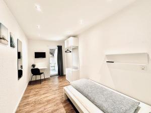 Jest to biały pokój z łóżkiem i biurkiem. w obiekcie Monteurzimmer ZIMMERzuVERMIETEN Oensingen w mieście Oensingen