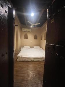 duże łóżko w pokoju z sufitem w obiekcie The traditional house w mieście Nizwa