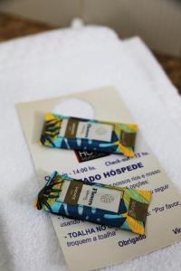dos paquetes de pasta de dientes encima de una toalla en Pousada Água Eterna - Próximo ao Museu de Cera, Hot Beach e Thermas dos Laranjais - By UP Hotel, en Olímpia
