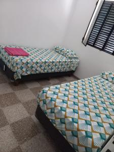 two beds sitting next to each other in a room at La casita de Aitana in Pergamino