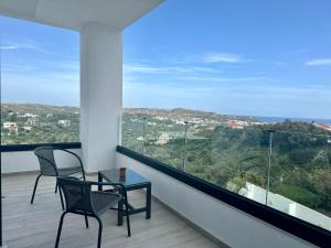 a balcony with two chairs and a table and a view at Habitat Inn Faliraki View Villa Rhodes in Kalithies