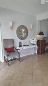 a living room with a chair and a mirror at Luxury Villa L'ile Maurice in Pointe aux Cannoniers