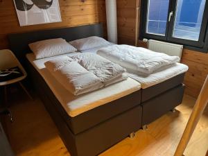 een bed met witte lakens en kussens erop bij FINS Holiday Home in Ermelo