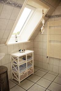 ダゲビュルにあるDeichkroneの天窓と白いキャビネット付きのバスルーム