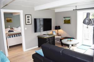 uma sala de estar com um sofá, uma televisão e uma cama em Haus Frieda / Aventoft em Aventoft