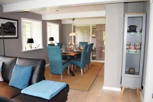 uma sala de jantar com uma mesa e cadeiras azuis em Haus Frieda / Aventoft em Aventoft