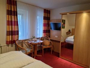 a hotel room with a bed and a table and a mirror at Café und Pension Höpen Idyll in Schneverdingen +54 photos