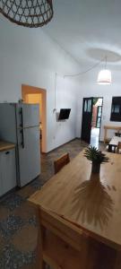 uma cozinha e sala de jantar com uma mesa de madeira e frigorífico em La casita de Aitana em Pergamino