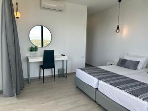 a bedroom with a bed and a desk with a chair at Habitat Inn Faliraki View Villa Rhodes in Kalithies