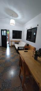 a living room with a wooden table and a flat screen tv at La casita de Aitana in Pergamino