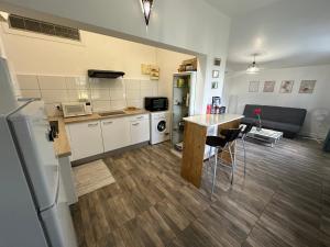 eine Küche und ein Wohnzimmer mit einem Tisch und einem Kühlschrank in der Unterkunft T2 à Convenance in Baie-Mahault