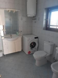 a bathroom with a washer and a toilet and a sink at Apartment Marija in Pula