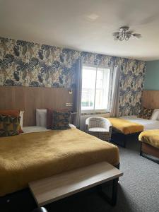 a hotel room with two beds and a window at The Crown Inn - By Whitney Inns in Keynsham