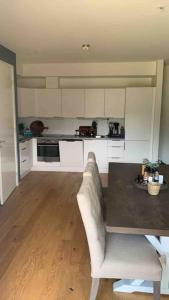 a kitchen with a couch and a table in a room at Moderne solrik leilighet - gratis lading/sentralt in Kristiansand