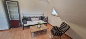 ein Wohnzimmer mit einem Sofa und einem Stuhl in der Unterkunft Ferienwohnung Haus Ella in Neunkirchen