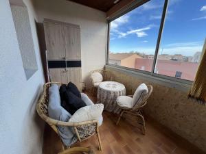 um quarto com cadeiras, uma mesa e uma janela em Appartement Valras-Plage, 2 pièces, 3 personnes - FR-1-701-67 em Valras-Plage