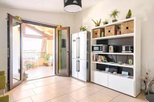 a kitchen with a white refrigerator in a room at Acquachiara Rooms in Villasimius