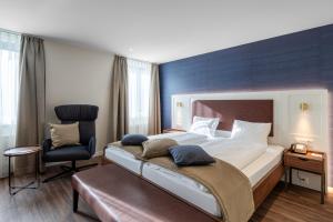 インターラーケンにあるHotel Du Nordのベッドルーム(大型ベッド1台、椅子付)