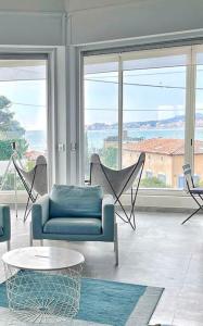 un salon avec un canapé, des chaises et des fenêtres dans l'établissement Villa avec piscine, Baie de Bandol, Accès plage, à Sanary-sur-Mer 46 autres photos
