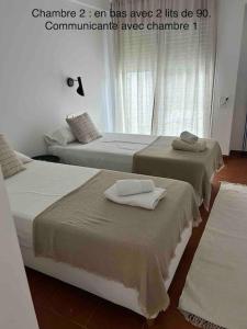 2 Betten mit Handtüchern darüber in einem Zimmer in der Unterkunft Maison Begur vue mer -piscine - à pied de la cala in Palafrugell