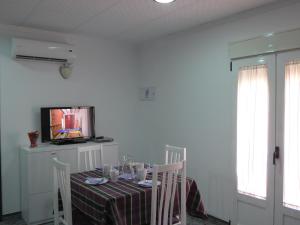 a dining room with a table and a television at Apartamentos Turisticos Ca Ramon in Beniarrés