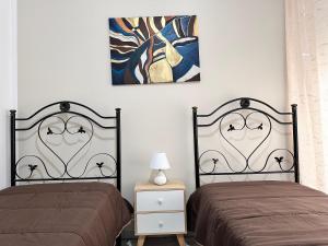twee bedden naast elkaar in een slaapkamer bij Pamir Casa Vacanze Appartamento in Trapani