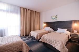 ein Hotelzimmer mit 2 Betten und einem Fenster in der Unterkunft Hotel Slavija in Belgrad
