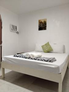 a bed with white sheets and towels on it at Moalboal Beach Front Hotel in Moalboal