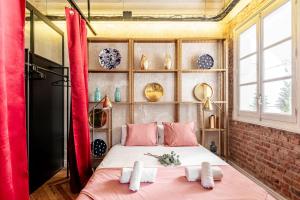 a bedroom with a bed with pink pillows at Charming Puerta de Alcalá in Madrid