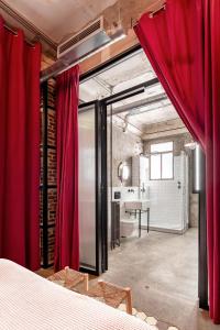 a bedroom with red curtains and a table in a room at Charming Puerta de Alcalá in Madrid