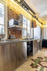 a kitchen with stainless steel appliances and a brick wall at Charming Puerta de Alcalá in Madrid