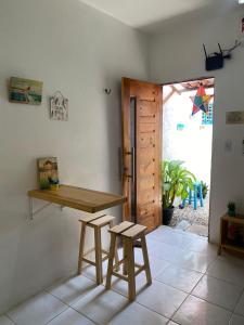 une chambre avec une table en bois et deux tabourets dans l'établissement Lotus Flat - Canoa Quebrada, à Aracati