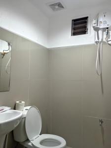 een witte badkamer met een toilet en een wastafel bij Moalboal Beach Front Hotel in Moalboal
