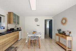 a kitchen with a table and a clock on the wall at HOME FAMILY's AVEIRO in Gafanha da Nazaré