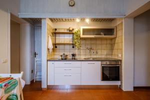 uma cozinha com armários brancos e um lavatório em Giardino al Mare em Forte dei Marmi