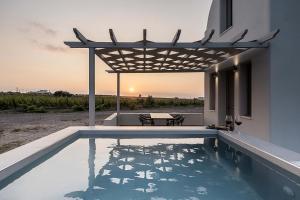 a swimming pool with a pergola on a house at MelivOia house collection in Foinikiá