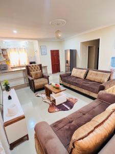 uma grande sala de estar com sofás e uma mesa em Hibiscus Apartments em Ndola