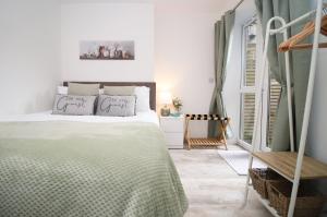 a white bedroom with a bed and a window at Luxury Apartment in Cardiff