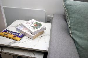 two books sitting on a table next to a couch at Luxury Apartment in Cardiff