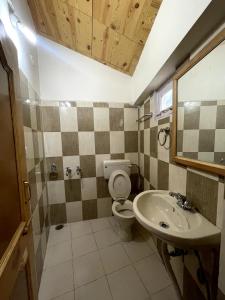 a bathroom with a toilet and a sink at Place To Reborn in Manāli