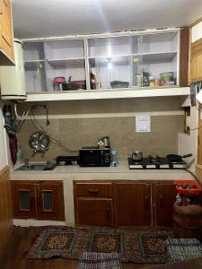 a kitchen with a stove and a counter top at Place To Reborn in Manāli